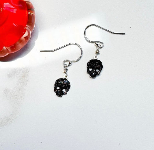 Tiny hand cut skull earrings