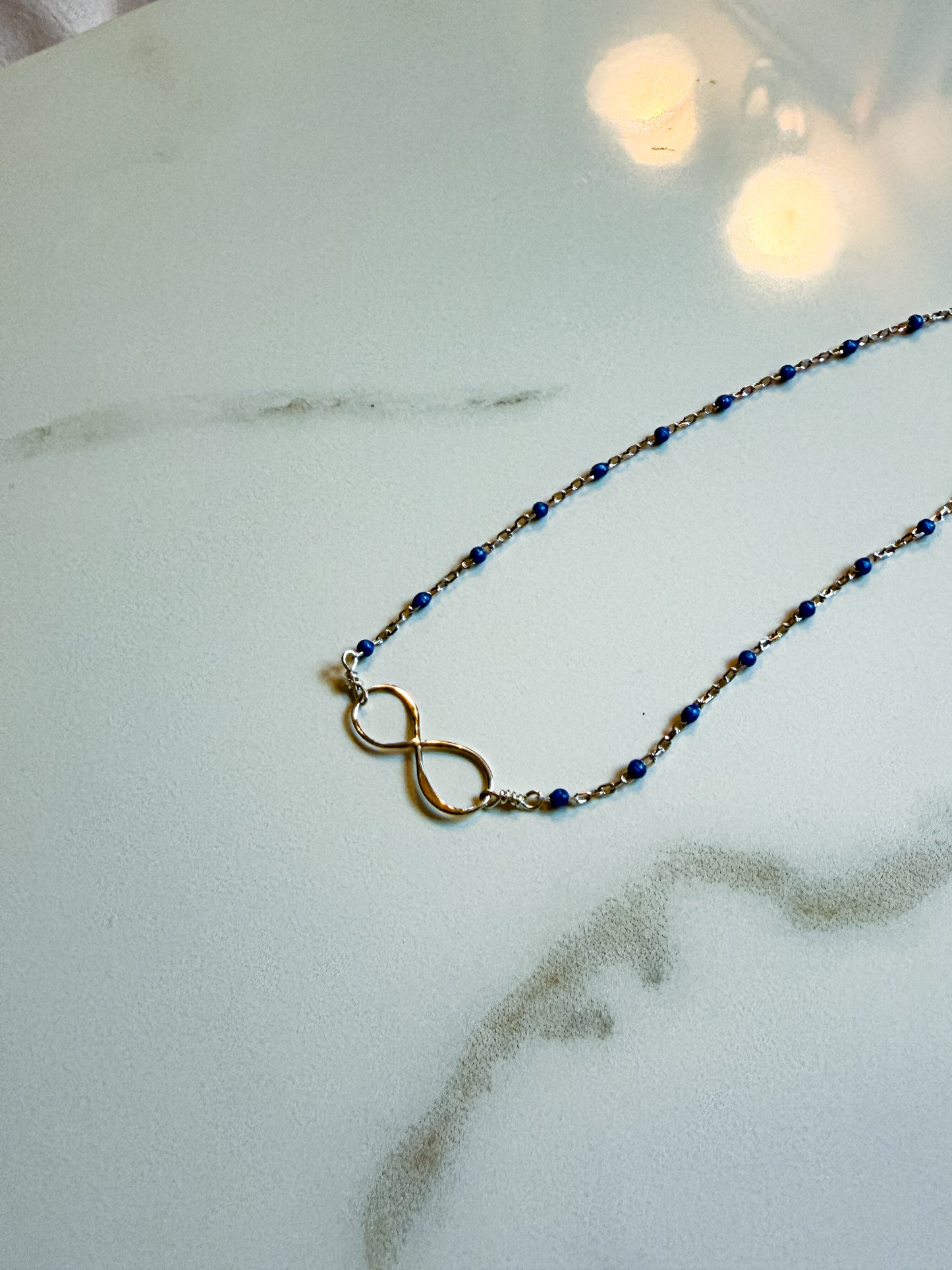 Delicate sterling infinity and blue enamel necklace